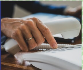 person's hand dialing a phone