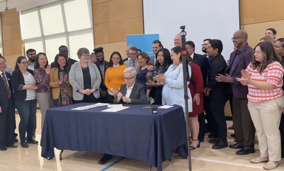 group photo immigrant justice bill signing