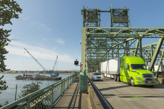 The barge is positioned adjacent to the Interstate Bridge. 