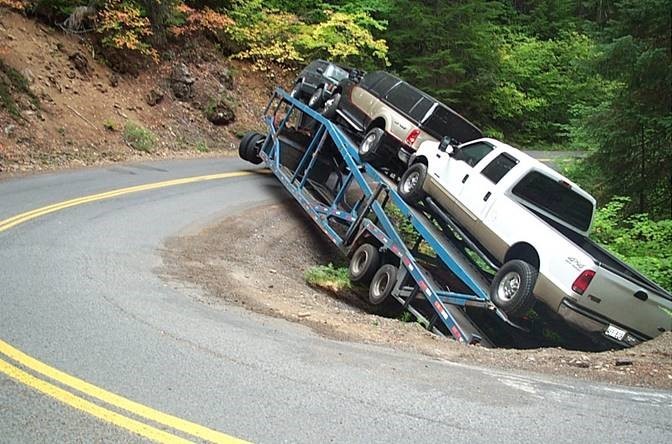 Images of tractor trailer hanging over edge of road embankment