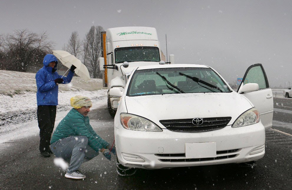 Vehicle chaining up before traveling over snowy Siskiyou Summit