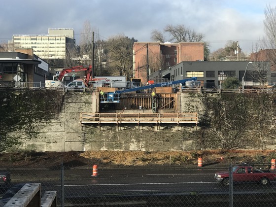 Crews work along the western I-405 retaining wall in preparation for the installation of Flanders Crossing.