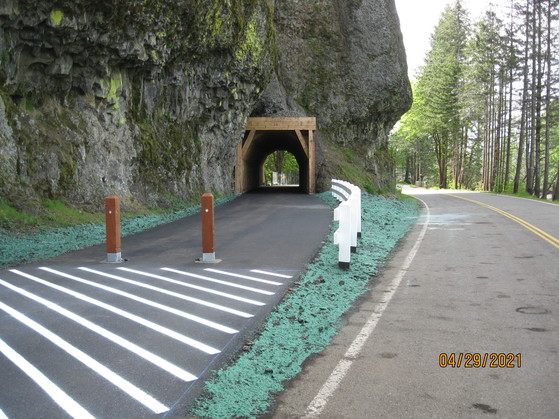 Pavement leads up to the new tunnel with wooden lining in the rock face