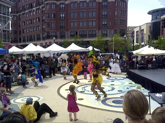Artists performing at a lively community gathering in an urban environment.