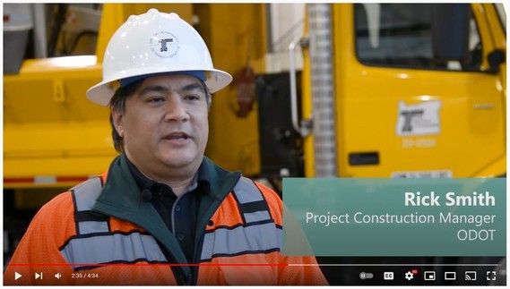 ODOT construction manager, Rick Smith, talking about the OR 217 Auxiliary Lanes Project in front of a yellow ODOT truck.