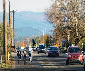 Roadway with vehicles in Molalla and 3 people riding bikes
