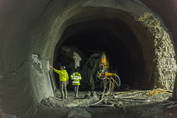 Two people stand in a large, arched tunnel 