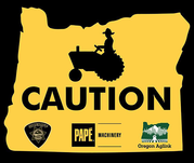 CAUTION: person driving farm equipment outlined by yellow outline of Oregon.