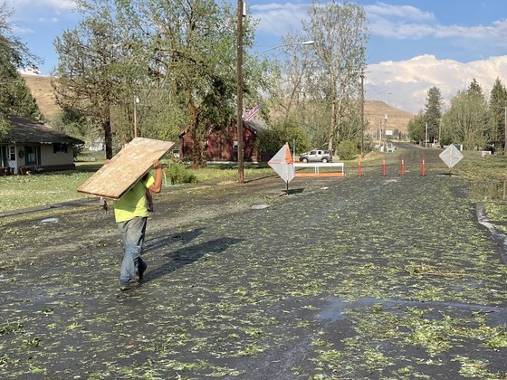 Willy Ramos of Global Electric takes plywood to a house after the hailstorm.