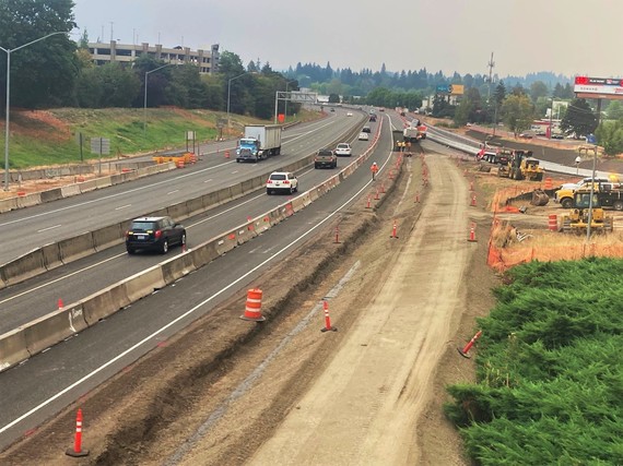 View of work zone that includes a flat dirt area adjacent to OR 217 travel lanes.