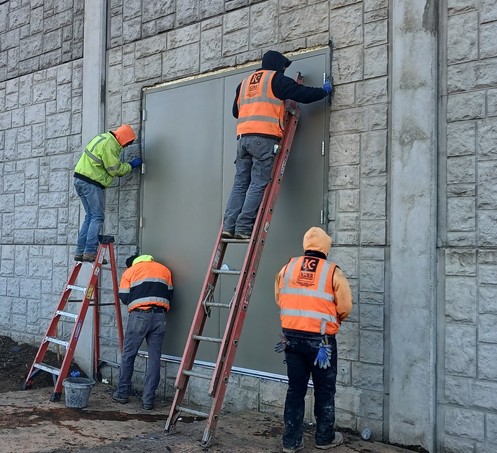 Crews installing a sound wall door