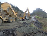 Heavy equipment builds a temporary lane through the U.S. 101 landslide