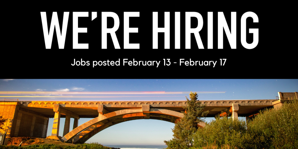 Bridge on the Oregon coast overlooking the ocean, with beautiful blue sky in the background and green shrubbery in the foreground.