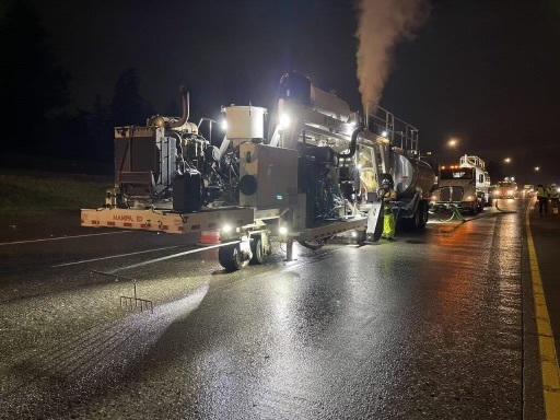 A nighttime work scene with heavy equipment on I-84. 