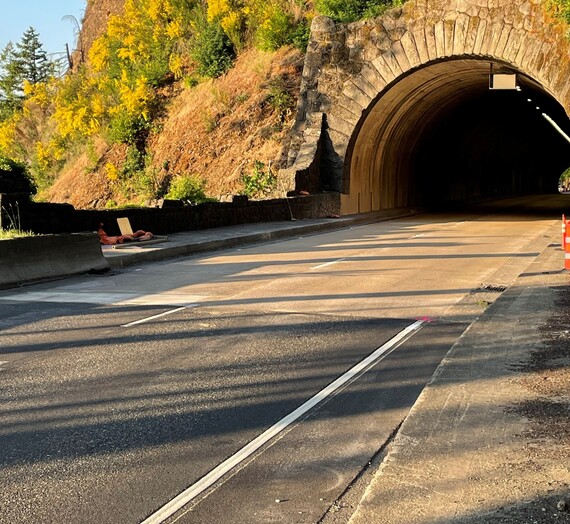 The stone masonry tunnel is visible in the background but the pavement is smooth without ruts. 