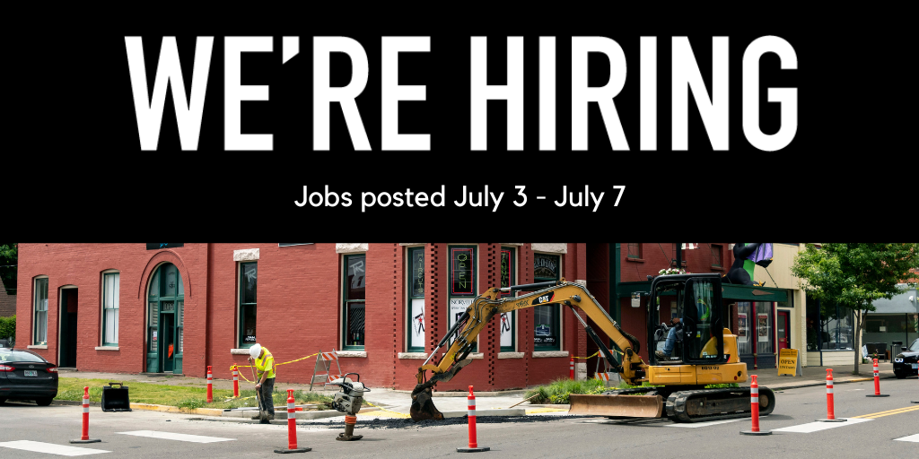 Photo of a crew working on an intersection in town with a backhoe digging a hole through the asphalt. 