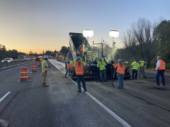 Crews compacting and smoothing the new pavement layers