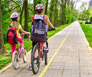 Two children riding bikes on a multi-use path.