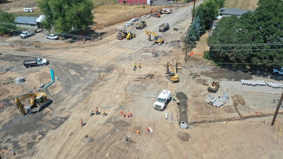 An aerial view of the intersection. There is no pavement, just dirt. Machinery around intersection. 