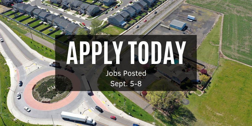 Aerial photo of a round about near some agricultural fields and residential housing. 