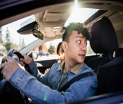 Teen driver scanning over shoulder in vehicle
