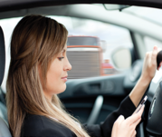 Woman driving a car while holding a cell phone