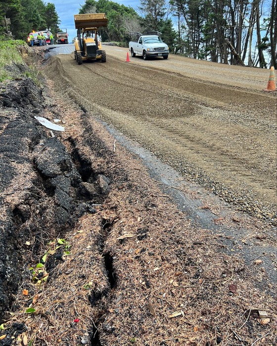 Crews laying down gravel across U.S. 101 as a temporary fix due to sunken grade.
