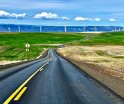 Central Oregon highway with blue sky and windmills in distance