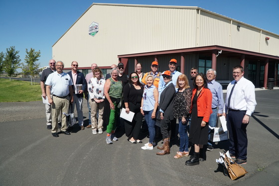 Group of legislators, ODOT staff, OTC members and local officials pose for a group photo in front of the Eastern Oregon Trade & Event Center.