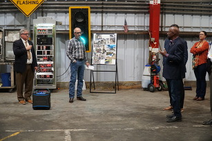 Presentation at ODOT maintenance facility with highway signs and transportation lights in the background