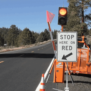 Gif showing an automated flagger device lowering it's stop flag