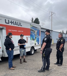 Law enforcement officers talk to household goods movers