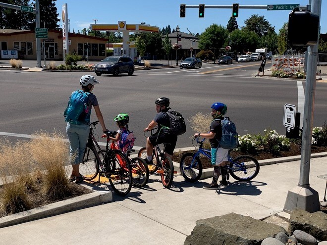 People on bikes waiting on the corner of an intersection