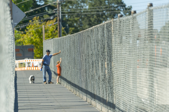 People watching construction from temporary bridge