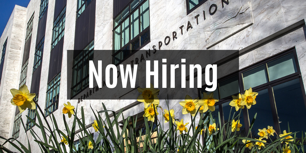 Now Hiring with Transportation Building and daffodils in background