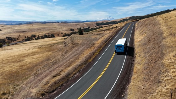 A bus driving along a winding road. 