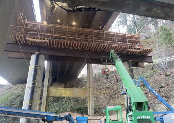 View of crews working beneath I-84 at McCord Creek while they prepare to remove the aging eastbound bridge.