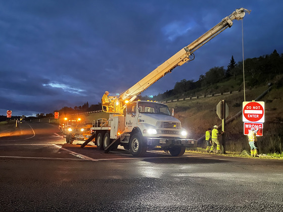 Workers install sign at I-5 Exit 113