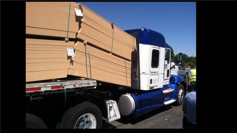 Unsecured load of lumber falling into truck cab