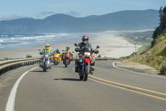 A group of motorcycles on highway 101 near the ocean.
