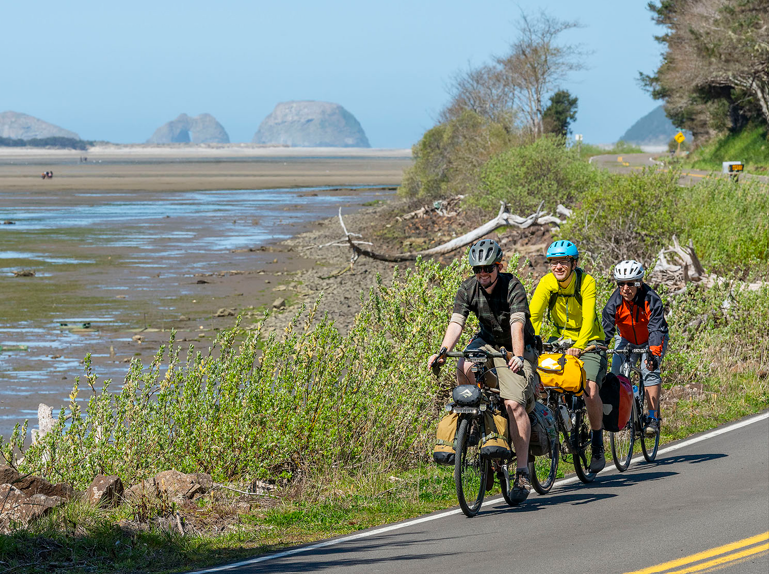 Three people on bikes, three capes view on Whiskey Creek Road.