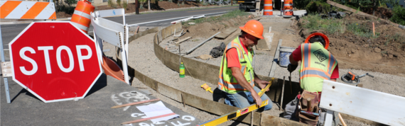 Photo showing curb ramp construction and work zone with stop sign