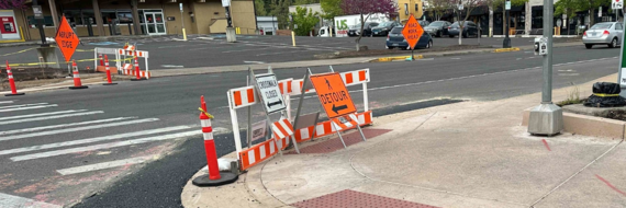 ADA curb ramp construction work zone photo showing temporary pedestrian detour signs