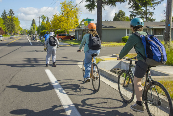 Children bike to school in the bike lane along a tow lane road.