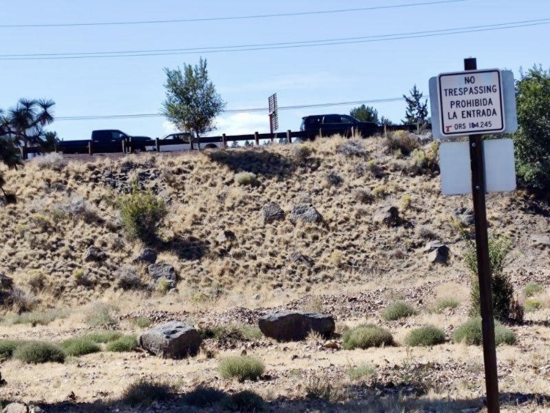 A no trespassing sign is posted near the highway