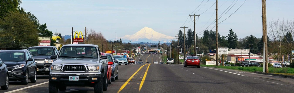 OR 8 through Hillsboro. Four lane highway with traffic driving both directions and businesses on the side of the highway.