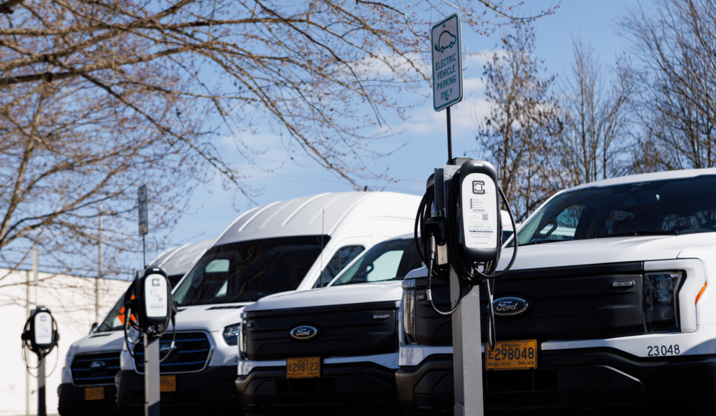 Electric vans lined up at chargers.