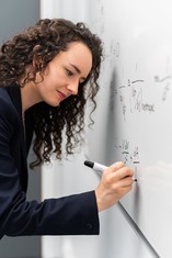 Woman writing on whiteboard