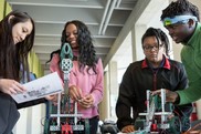 three high school students designing with robotics equipment