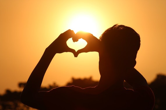 silhouette of man making heart shape with hands 